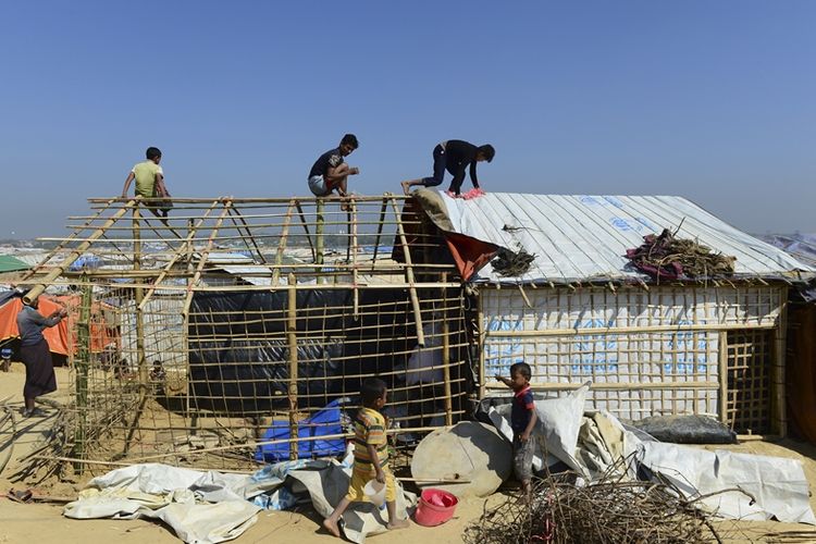 Para pengungsi Rohingya bekerja sama mendirikan tenda penampungan di kamp pengungsi di Kutupalong, distrik Ukhia, Bangladesh.