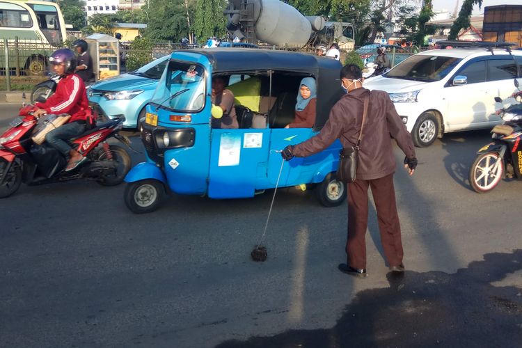 Abdul Rohim, penggagas Komunitas Sapu Bersih (Saber) ranjau paku tengah menyisir jalan raya, di daerah Pesing, Jakarta Barat, Rabu (15/11/2017).