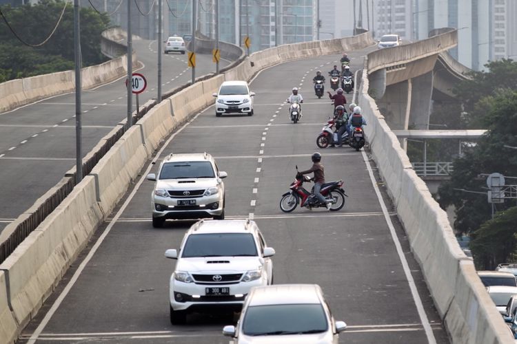 Pengendara sepeda motor nekat melawan arah saat berlangsung razia di jalan layang non tol (JLNT) Kampung Melayu-Tanah Abang, Jakarta, Selasa (25/7/2017). Pengendara motor masih nekat memasuki dan melintasi JLNT tersebut baik dari arah Tanah Abang maupun Kampung Melayu. KOMPAS IMAGES/KRISTIANTO PURNOMO