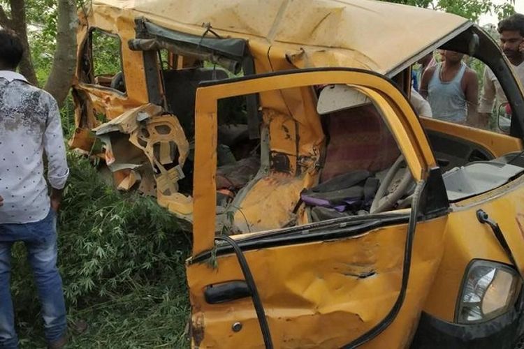 Warga di Kushinagar, India, mengerumuni van berwarna kuning yang bertabrakan dengan kereta Kamis waktu setempat (26/4/2018). Akibat insiden itu, 13 anak sekolah dilaporkan tewas.