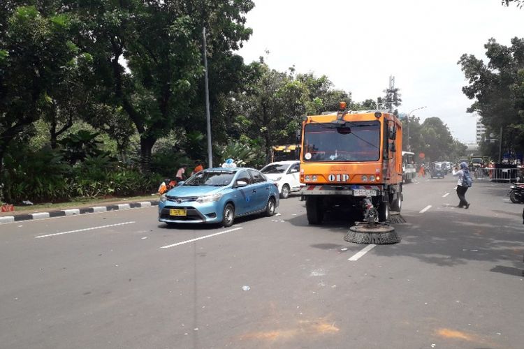 Sebuah mobil sweeper membersihkan sampah dari Jalan Medan Merdeka Selatan setelah berakhirnya pesta juara Persija di Balai Kota DKI Jakarta, Sabtu (15/12/2018).