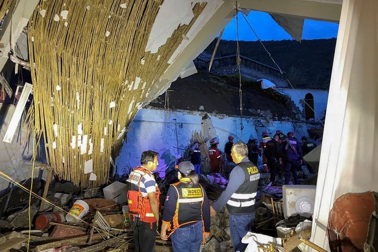 Petugas memeriksa kondisi hotel yang rusak akibat diterjang tanah longsor di Peru, Sabtu (26/1/2019).