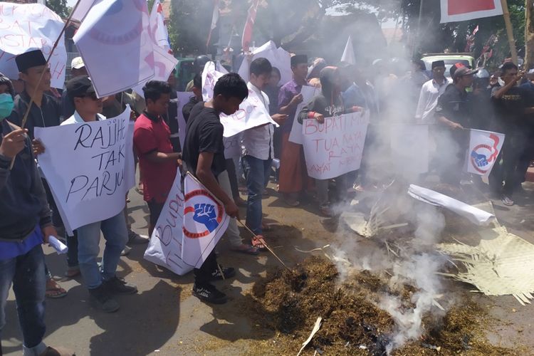 Petani tembakau di Pamekasan berunjuk rasa di depan kantor Bupati Pamekasan sambil membakar tembakau rajangan yang baru selesai dipanen.