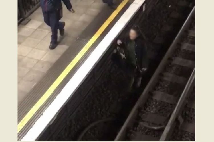 Aksi seorang perempuan di London mengambil ponselnya yang terjatuh di rel kereta stasiun Aldgate East, Kamis (18/1/2018). (Instagram alex1236)