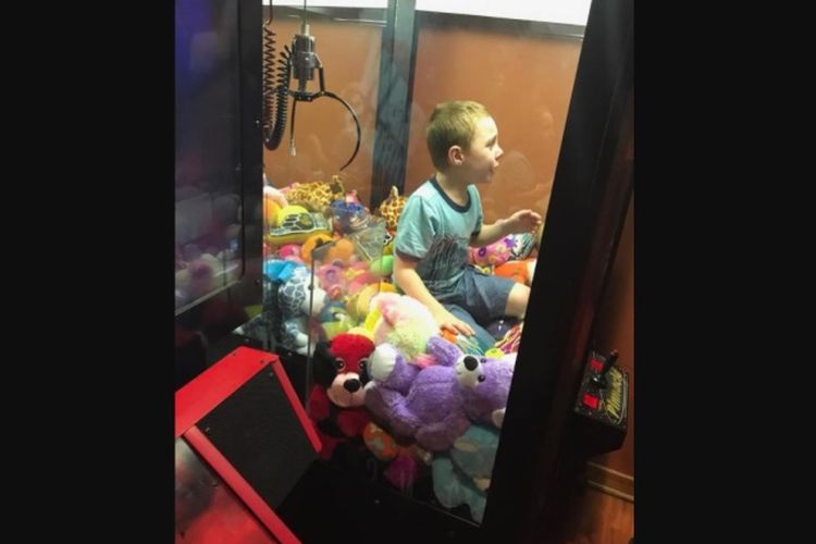 Bocah bernama Mason terjebak di dalam mesin permainan setelah merangkak masuk untuk mengambil boneka yang berada di dalamnya.