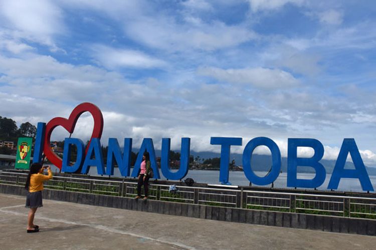 Wisatawan berfoto di Dermaga Parapat Danau Toba, Simalungun, Sumatera Utara, Minggu (4/11/2018). Menpar Arief Yahya menyatakan Danau Toba menjadi prioritas pertama pemerintah pusat sebagai Kawasan Strategi Pariwisata Nasional (KSPN), bersama Labuan Bajo (NTT), Mandalika (Lombok), dan Borobudur (Jateng), yang diharapkan menjadi destinasi wisatawan internasional. ANTARA FOTO/Andika Wahyu/
