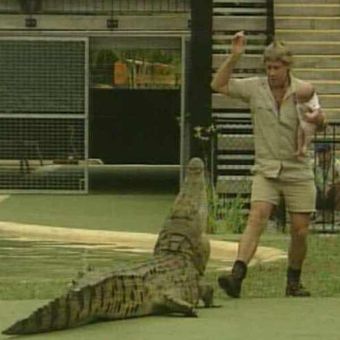 Steve Irwin menggendong putranya yang berusia, saat memberi makan buaya  di Kebun Binatang Australia di Beerwah pada 2004. (Channel Seven via Courier Mail)