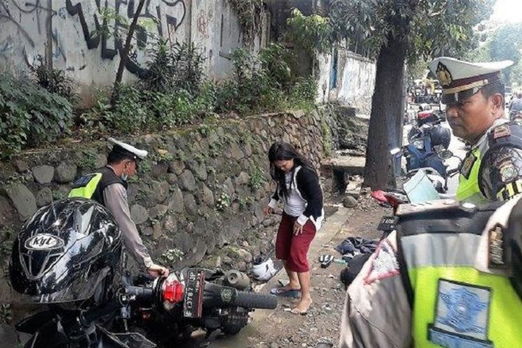 Sepeda motor Heni masuk got, di Pasar Minggu, Jakarta Selatan, Rabu (27/2/2019). Heni sebelumnya panik karena ditilang. 