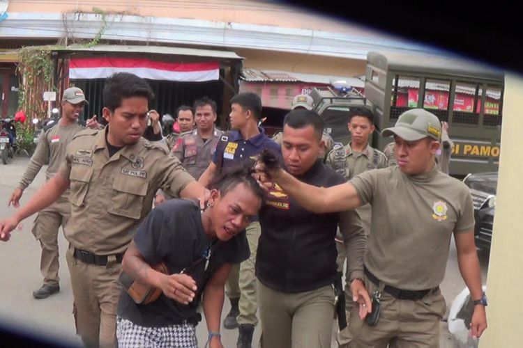 Seorang pria digelandang oleh sejumlah polisi palong praja (Pol PP) usai mengrusakan Pos Satpol PP. Kamis, (21/9/2017).