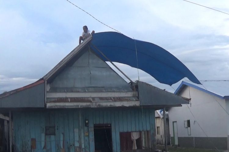 Pasca-dilanda puting beliung, warga desa Munte, kecamatan Tana Lili, Luwu Utara membenahi atap rumah mereka dengan menggunakan terpal sebagai pengaman sementara, Senin (04/03/2019) 