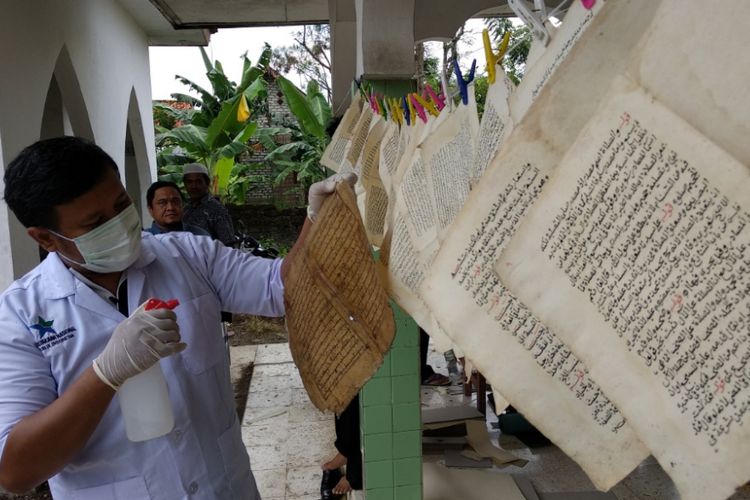 Petugas dari Perpustakaan Nasional sedang melakukan laminasi kitab berusia ratusan tahun di Pamekasan