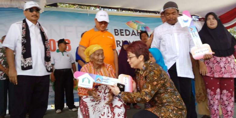 Theresia Rustandi, Sekretaris Perusahaan dan Kepala CSR PT Intiland Properti Tbk menyerahkan bantuan kepada Tura (85 thn), salah satu warga Sungailiat, Bangka Belitung, Jumat (13/4/2018). Bantuan tersebut diberikan melalui program Intiland Teduh pada Bedah Rumah HUT REI ke-46.
