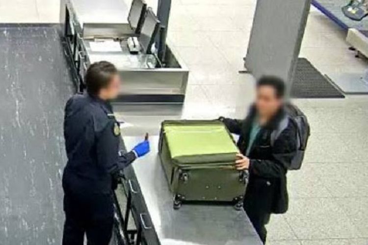Seorang petugas imigrasi di bandara internasional Perth, Australia sedang memeriksa koper milik seorang penumpang.