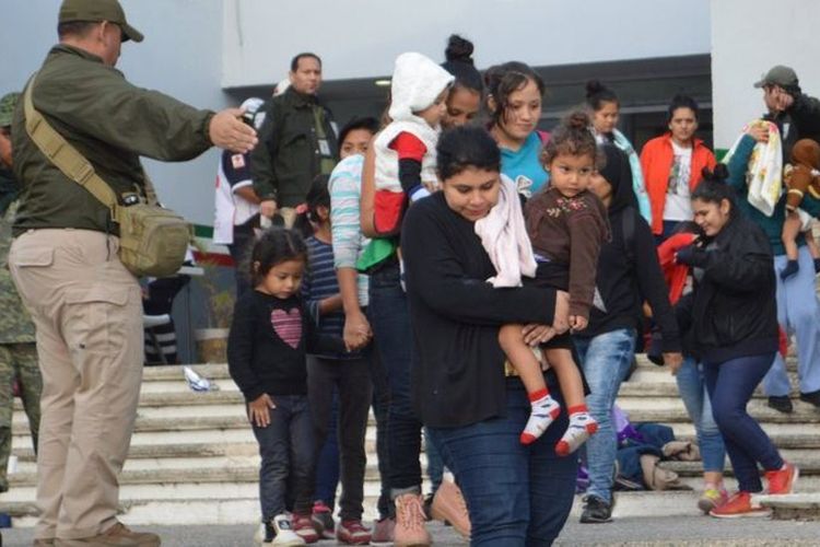Pria, perempuan dan anak-anak migran terbebas dari truk sempit setelah ditemukan berjejalan di truk di Tamaulipas, di selatan perbatasan Texas. (BBC)