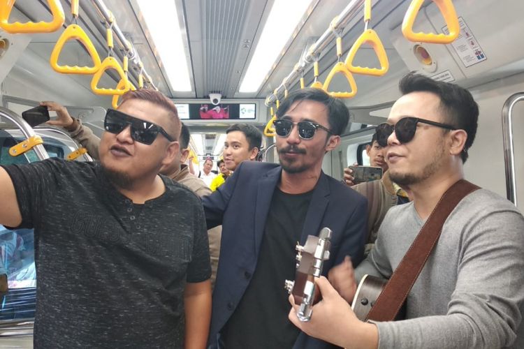 ST12 Zai (Vokalis), Indra (Bassis), dan Pepep (Gitaris/keyboardist) saat ngamen di dalam kereta Light Rail Transit (LRT) Palembang, Sumatera Selatan, Kamis (20/9/2018). Usai ngamen di LRT Palembang, ST 12 berencana untuk membuat video klip.
