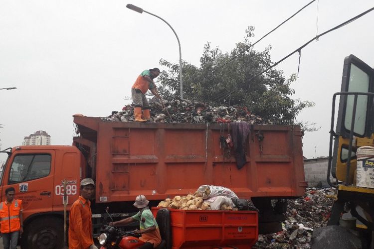 Petugas, Selasa (23/10/2018), mengangkut sampah dari TPS Muara Baru, Jakarta Utara, ke dalam truk yang akan membawa sampah ke TPST Bantargebang, Bekasi.  
