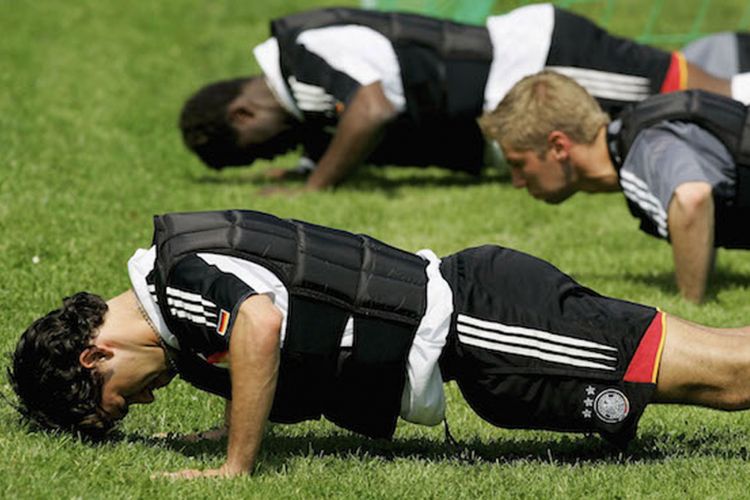 Pemain bola tim nasional Jerman mengenakan rompi beban dalam sebuah sesi latihan