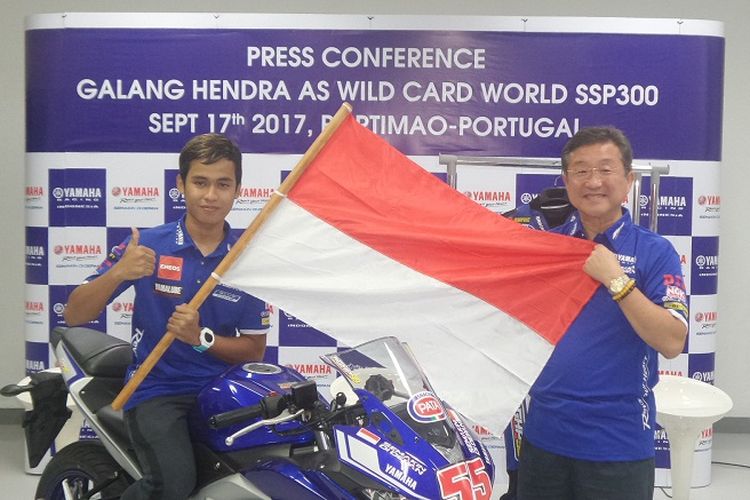 Pebalap Yamaha Indonesia, Galang Hendra Pratama, berpose dengan membentang bendera Indonesia bersama Presiden Direktur PT Yamaha Indonesia Motor Manufacturing, Minoru Morimoto, di Jakarta, Kamis (31/8/2017).