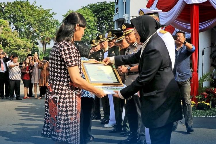 Wali Kota Surabaya Tri Rismaharini memberikan penghargaan kepada almarhum Aloysius Bayu melalui sang istri, Senin (21/5/2018)