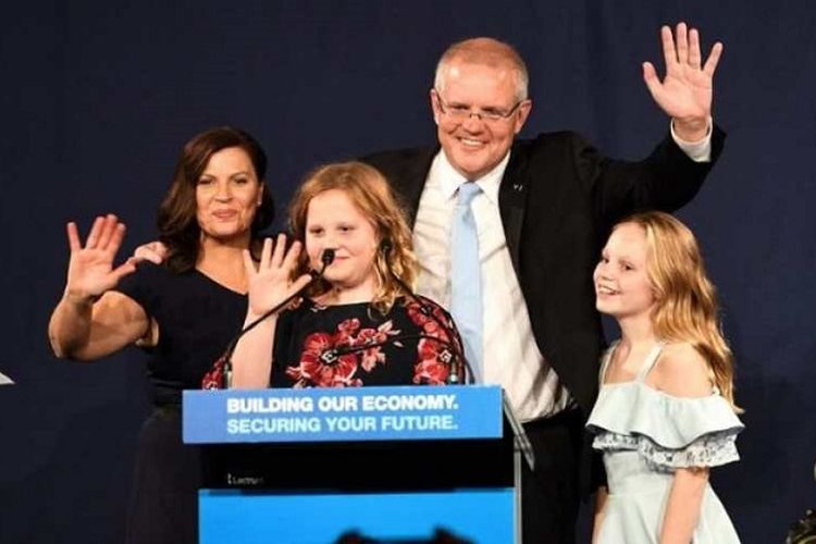 Perdana Menteri Australia Scott Morrison dan keluarga melambaikan tangan usai menyampaikan pidato kemenangan di Sydney. Morrison memimpin Koalisi meraih kemenangan mengejutkan di pemilu federal Australia, Sabtu (18/5/2019)