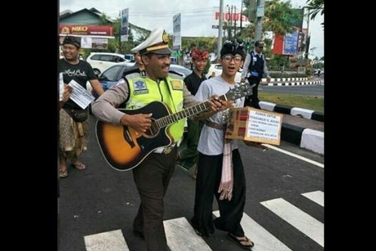 AKP Niko Ruing ketika membantu para relawan mengumpulkan dana di Sunset Road, Kuta, Badung, Bali. 
