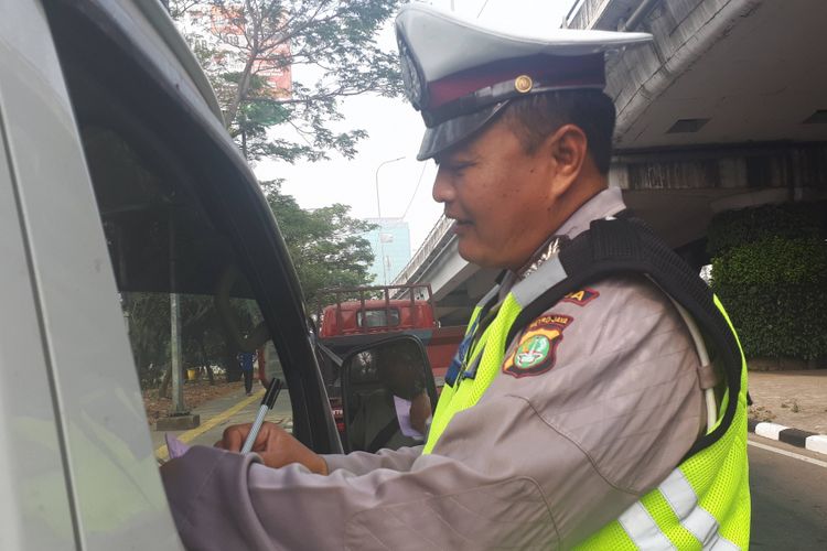 Mobil berplat genap dihentikan polisi saat melintas di Simpang Perintis Kemerdekaan, Cempaka Putih, Rabu (1/8/2018)