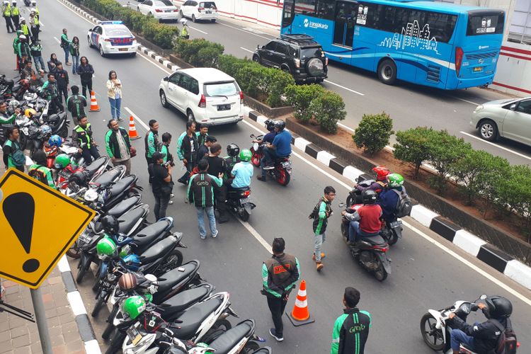 Pengemudi ojek online yang tergabung dalam komunitas Gerakan Aksi Roda Dua (Garda) melanjutkan aksi unjuk rasa ke kantor pusat Grab di Lippo Kuningan, Jakarta Selatan, Rabu (19/9/2018). Saat tiba di Lippo Kuningan, mereka memaksa pengemudi ojek lainnya untuk melakukan demo dengan iming-iming uang sebesar Rp 2.000 hingga Rp 20.000. 