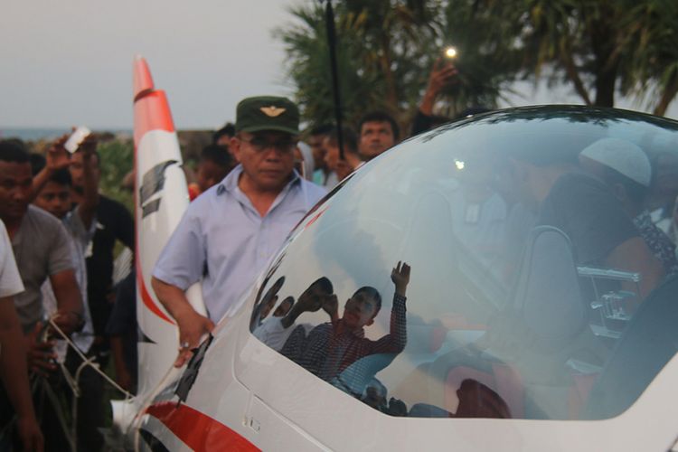 Gubernur Aceh Irwandi Yusuf (topi hijau) tampak di tengah kerumunan warga saat berlangsungnya evakuasi pesawat pribadi jenis Shark Aero yang dipiloti Irwandi, usai mendarat darurat di tepi pantai di Desa Lam Awe, Kecamatan Peukan Bada, Kabupaten Aceh Besar, Sabtu (17/2/2018) siang. Pesawat tersebut dikemudikan dalam perjalanan kunjungan kerja ke sejumlah kabupaten. Irwandi dan satu penumpang lainnya, Asisten II Pemerintahan Aceh, Taqwallah, dilaporkan dalam keadaan selamat.
