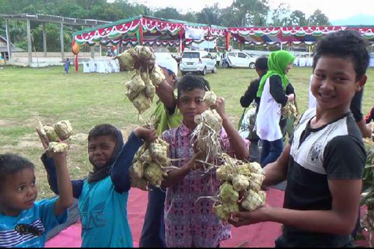 Sejumlah bocah memperlihatkan ketupat seusai pesta adat di Desa Gudang Bangka Selatan.