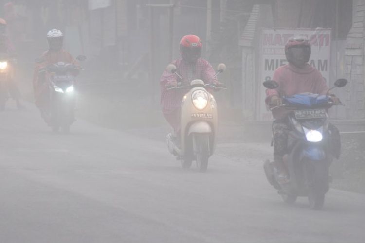 Sejumlah pengendara melintas saat terjadi hujan abu di Mojosongo, Boyolali, Jawa Tengah, Selasa (3/3/2020). Hujan abu terjadi di beberapa wilayah Boyolali akibat erupsi Gunung Merapi pada pukul 05.22 WIB dengan tinggi kolom 6.000 meter. 
