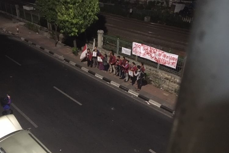 Sekelompok mahasiswa peserta demo pada Selasa (24/9/2019) bertahan di sekitar kawasan Stasiun Palmerah, Jakarta Pusat, hingga Rabu (25/9/2019) dini hari. Mereka menyempatkan diri berfoto di depan poster yang masih terpasang di pagar pembatas rel di sisi selatan stasiun di jalur jalan mengarah ke Permata Hijau.