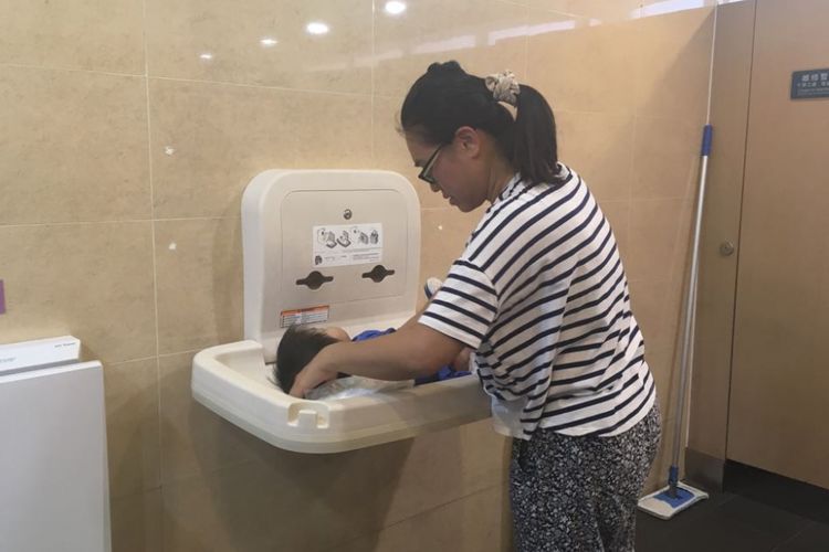 Pengunjung Ocean Park Hongkong yang sedang mengganti popok bayi di toilet wanita.