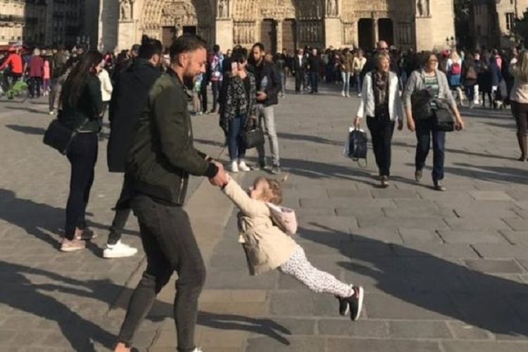 Foto yang memperlihatkan ayah dan anak ketika bermain di depan Gereja Notre Dame. Foto tersebut diambil satu jam sebelum kebakaran terjadi/