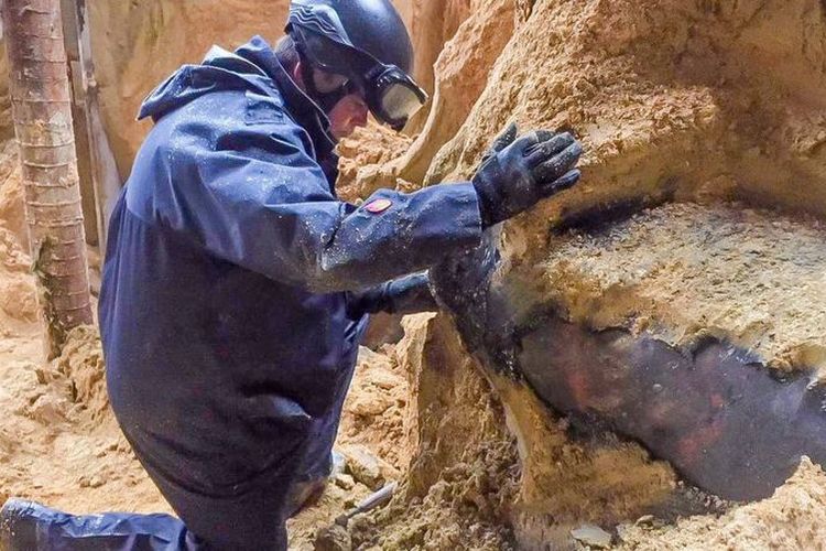 Petugas dari tim penjinak bom memeriksa bom yang ditemukan di lokasi konstruksi di Hong Kong, Rabu (31/1/2018).