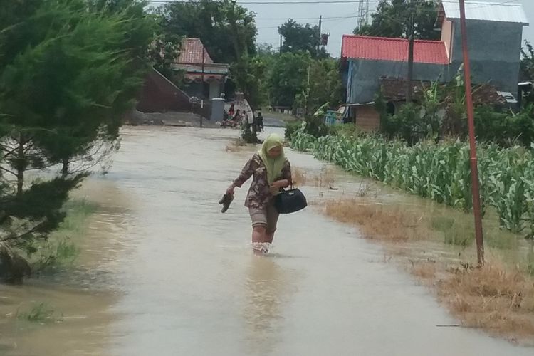 Warga desa Manggungsari Weleri saat berjalan melawan banjir. 