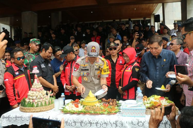 Kapolda Sumatera Selatan Irjen Pol Zulkarnain Adinegara saat memotong tumpeng bersama buruh di halaman kantor DPRD Sumsel dalam memperingati hari buruh sedunia, Rabu (1/5/2019).