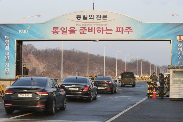 Tentara Korea Selatan memberi hormat saat kendaraan yang membawa Menteri Unifikasi Korea Selatan Cho Myoung Gyon dan delegasi lainnya mengarah ke Panmunjom di Zona Demiliterisasi di Paju, Korea Selatan, Selasa (9/1/2018). (AP Photo)