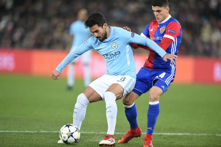 Gelandang Manchester City, Ilkay Guendogan, mencoba melindungi bola dari upaya pemain FC Basel merebutnya pada pertandingan babak 16 besar Liga Champions, 13 Februari 2018.