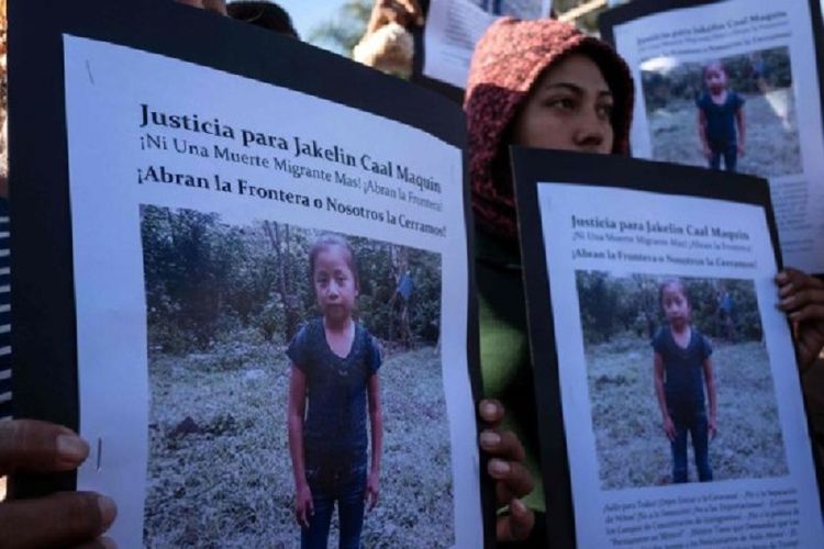 Para migran melakukan demonstrasi di depan penampungan sementara di Tijuana, Meksiko, sambil membawa poster Jakelin Amel Rosmery Caal. Jakelin adalah bocah migran asal Guatemala yang tewas usai ditahan karena melintasi perbatasan Amerika Serikat secara ilegal.