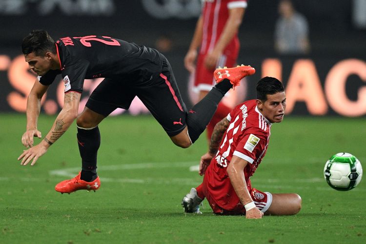 Gelandang Bayern Muenchen, James Rodriguez (kanan), berduel dengan gelandang Arsenal, Granit Xhaka, dalam pertandingan International Champions Cup di Shanghai, 19 Juli 2017.