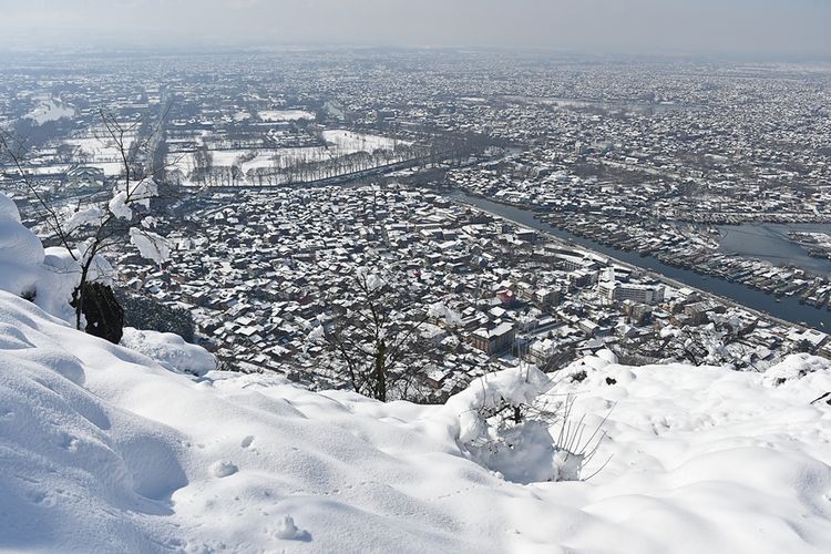 Rumah-rumah penduduk tampak putih akibat hujan salju lebat yang turun di wilayah Srinagar, Kashmir, India, pada 8 Februari 2019.