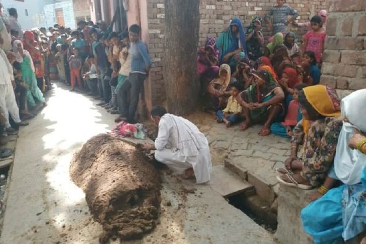Warga melihat gundukan kotoran sapi yang berisi jenazah Devendri. Perempuan 35 tahun itu tewas setelah melaksanakan ritual untuk menyembuhkan gigitan ular yang diderita.