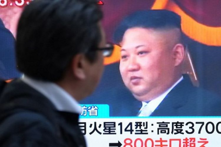 Seorang pejalan kaki melewati televisi yang menayangkan gambar pemimpin Korea Utara, Kim Jong Un, di jalanan Tokyo, Jepang. Kim Jong Un menyebut kesuksesan Korea Utara meluncurkan Hwasong-15 telah membuat mereka sebagai negara nuklir sejajar dengan Amerika Serikat maupun Rusia. (29/11/2017)