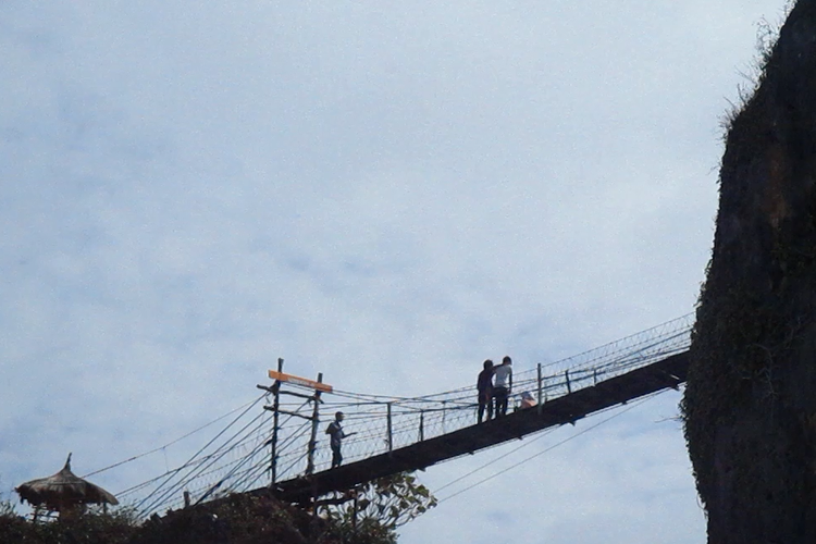 Pengunjung menyebrang di bukit Pantai Siung