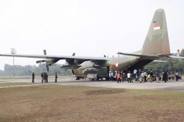 Karung berisi garam dikeluarkan dari pesawat Hercules milik TNI di bandara di Pekanbaru, Riau, untuk persiapan hujan buatan, 22 Juni 2013.