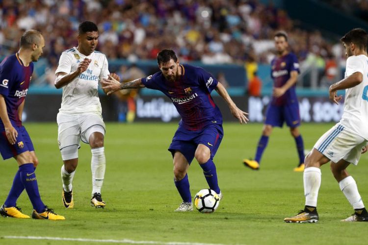 Lionel Messi mencoba lepas dari pengawalan pemain belakang lawan saat Barcelona berhadapan dengan Real Madrid dalam ICC 2017 di Stadion Hard Rock Miami, Sabtu (26/7/2017).