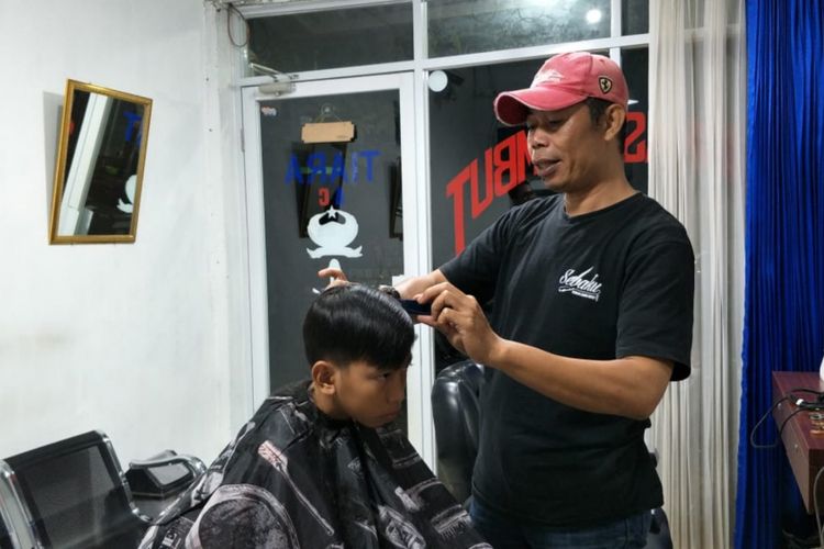 Agus Wahidin (49), tukang cukur pribadi Presiden Republik Indonesi ke-6 Susilo Bambang Yudhoyono (SBY) saat sedang cukur rambut pelanggannya, Jumat (1/2/2019).
