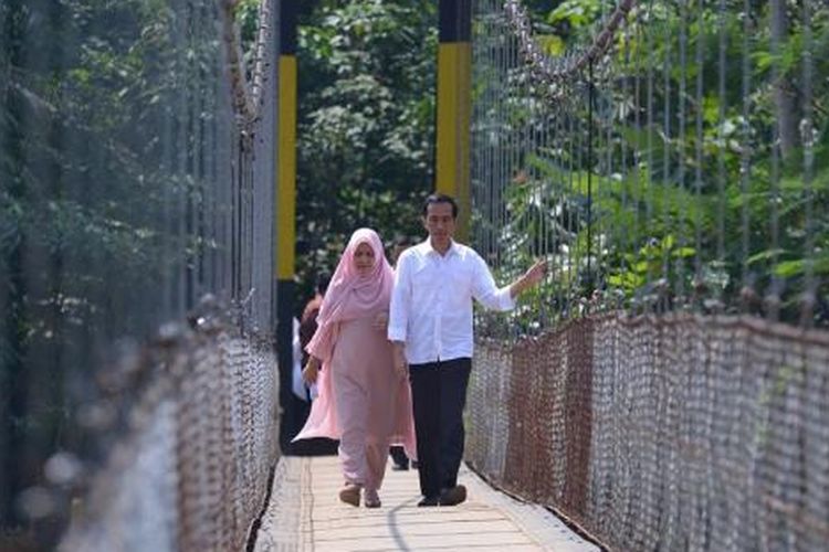 Presiden Joko Widodo dan Ibu Negara Iriana meniti jembatan gantung baru di Kampung Ranca Garut, Sangiang Tanjung, Kalanganyar, Lebak, Banten, Senin (4/7/2016).