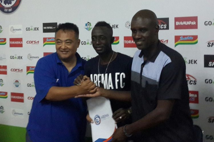 General Manager Arema FC Ruddy Widodo (kiri) bersama Makan Konate (tengah) saat menunjukkan dokumen perpanjangan kontrak di Stadion Kanjuruhan, Kabupaten Malang, Minggu (9/12/2018)