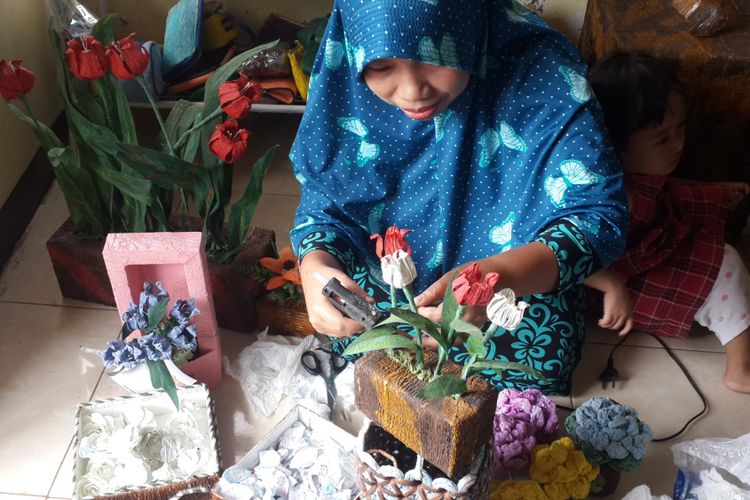 Yunita Lestari Ningsih (36) warga Kelurahan Tunjung Sekar, Kecamatan Lowokwaru, Kota Malang saat merajut bunga hias dari bekas popok, Selasa (3/10/2017)
